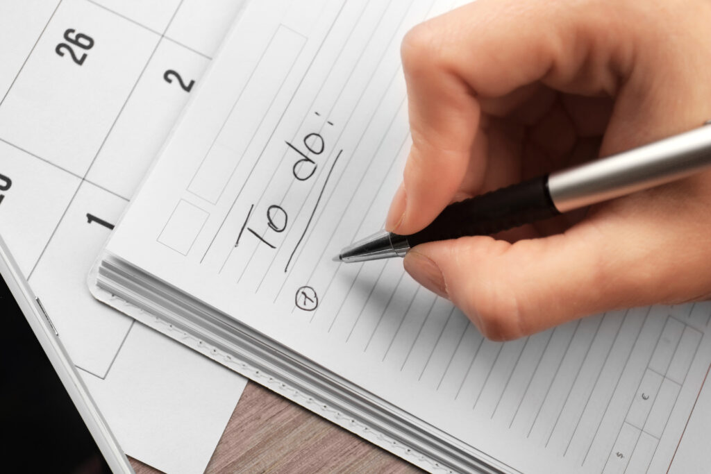 Female hand writing to do list in notebook, closeup