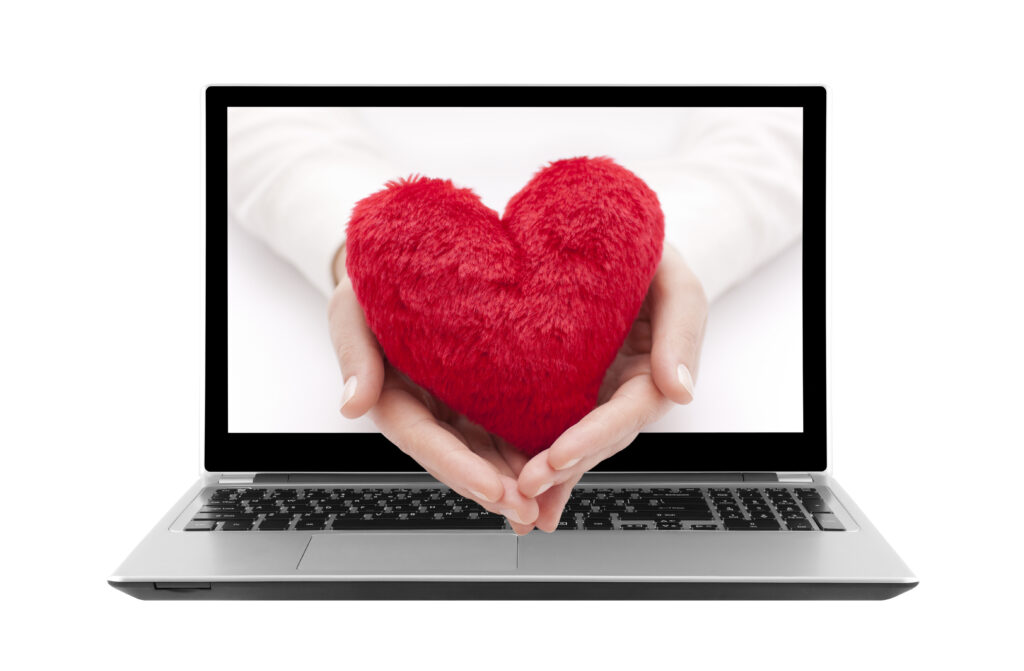 red heart in hand exiting computer screen